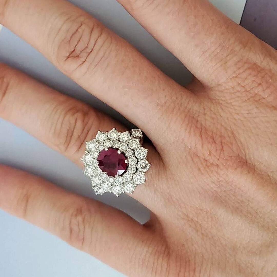 Sortija tipo solitario realizada en oro blanco de Ley que tiene como protagonista un centro de rubi natural talla oval de 2 cts. de peso decorado por roseta de diamantes naturales talla brillante Sortija tipo solitario realizada en oro blanco de Ley, que tiene como protagonista un centro de rubí natural talla oval de 2 cts. de peso decorado por roseta de diamantes naturales talla brillante.